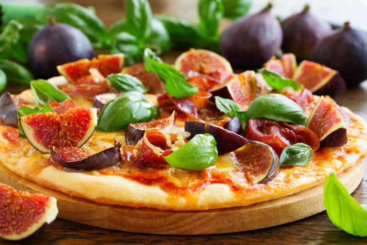 pizza e fichi su tagliere di legno