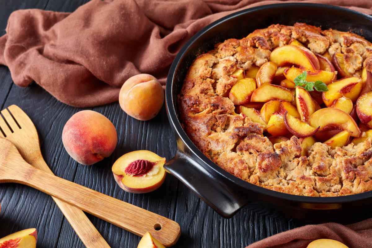 teglia tonda con torta con marmellata di pesche