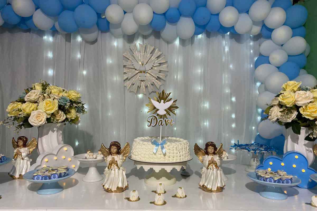 tavola allestita con decorazioni e torta di battesimo con la panna