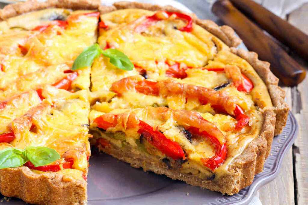 vassoio con fette di torta salata con peperoni e zucchine