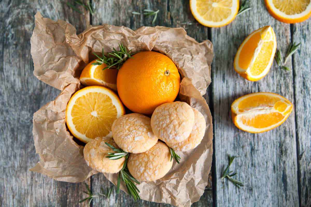 ciotola con biscotti all'arancia e frutti tagliati a spicchi