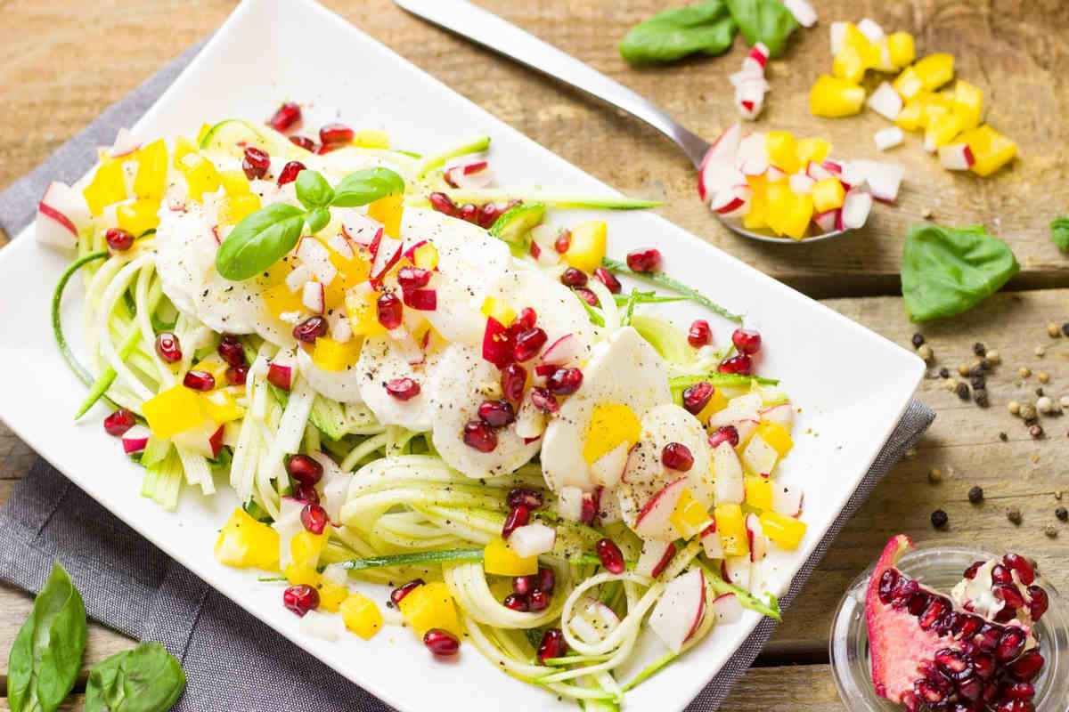 piatto di spaghetti di zucchine in insalata con melograno