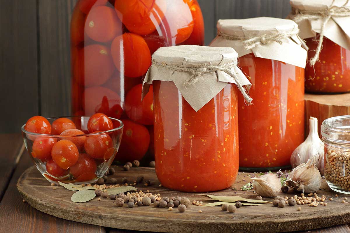 Conserva di pomodoro in barattoli di vetro su tavolo di legno