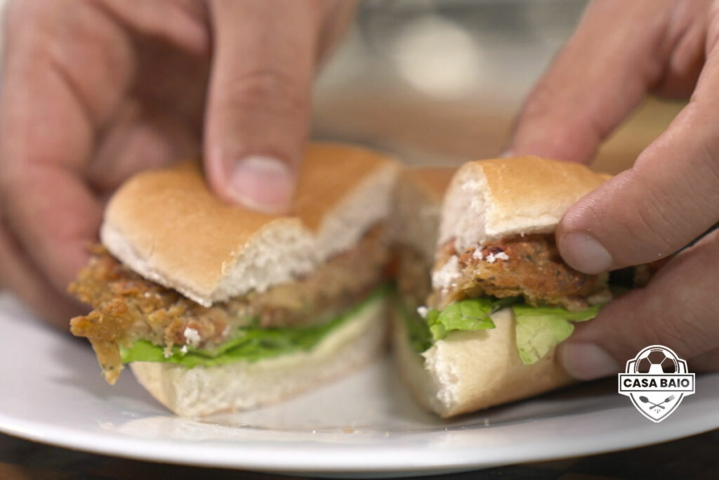 baiocchini taglia un panino con hamburger di ceci e barbabietola