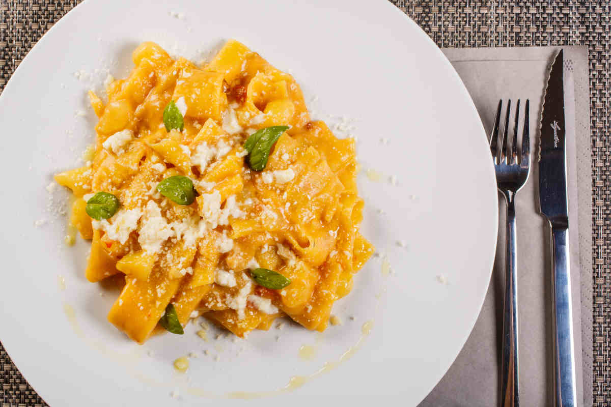 piatto bianco piano con pasta e patate e pezzetti di provola