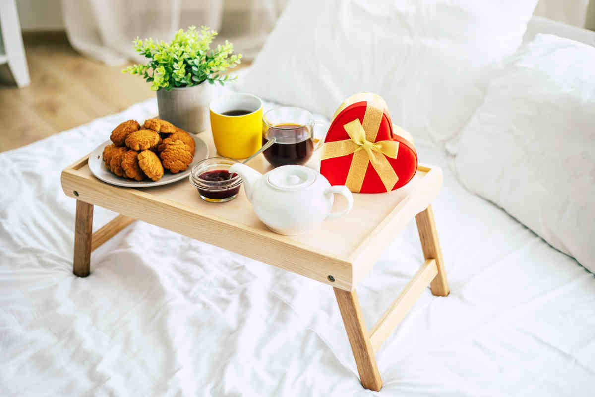 vassoio per la colazione a letto con biscotti, tè spremuta di arancia e cofanetto di cioccolatini a forma di cuore per san valentino