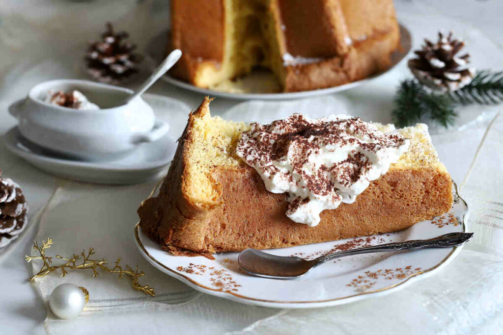 piatto con fetta di pandoro farcito su tavola natalizia