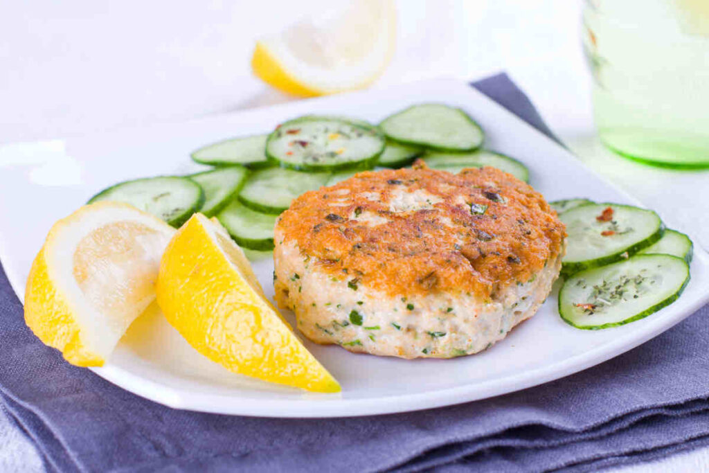 piatto piano con hamburger di salmone e cetrioli