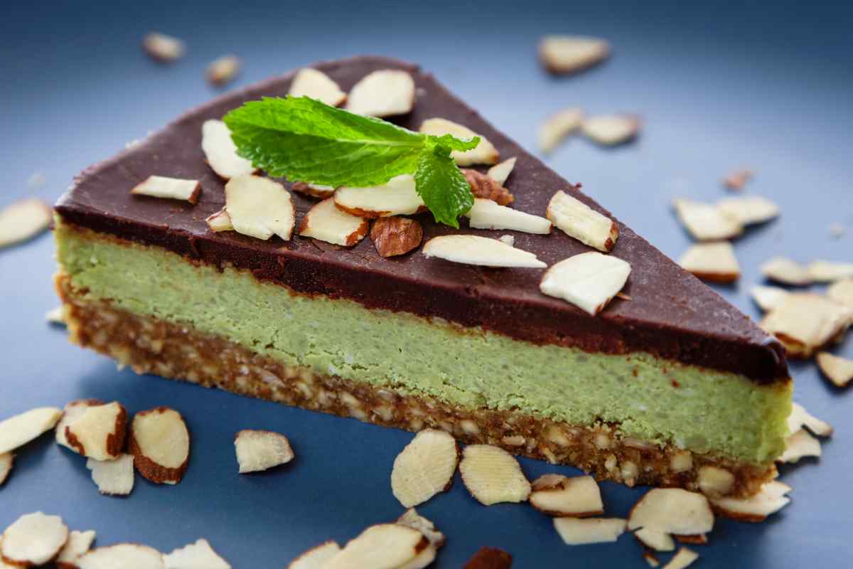 Fetta di cheesecake menta e cioccolato decorata con lamelle di mandorle