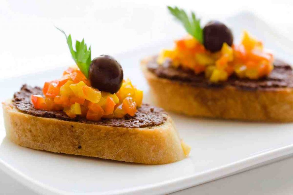 Bruschette estive olive e peperoni su un piatto