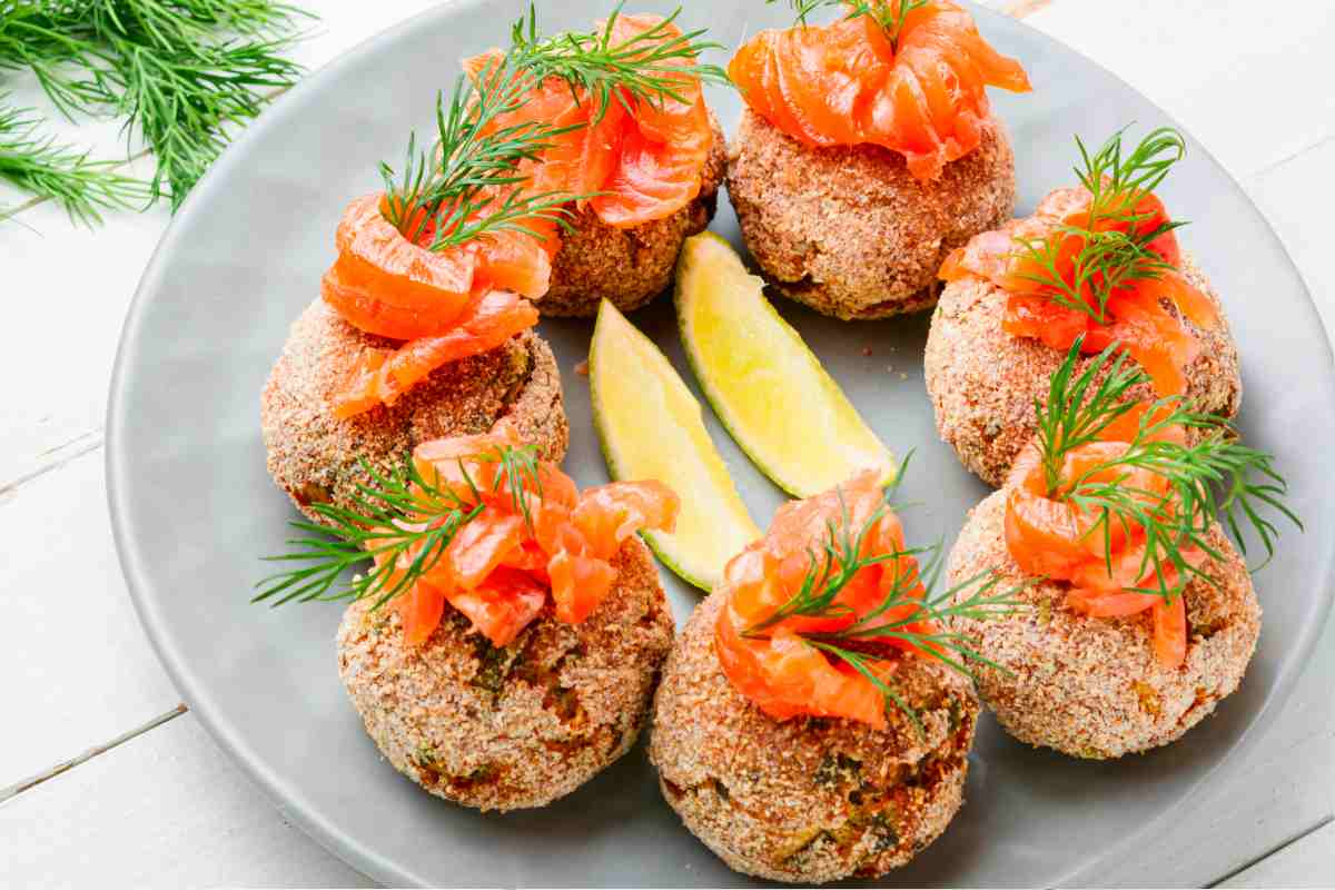 piatto con diverse polpette di pesce presentate in maniera originale con decorazioni di salmone affumicato