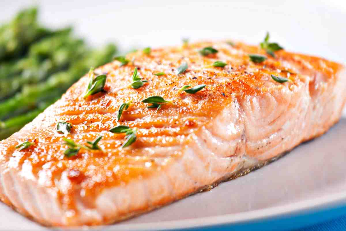 Salmone al forno decorato con erbe in un piatto