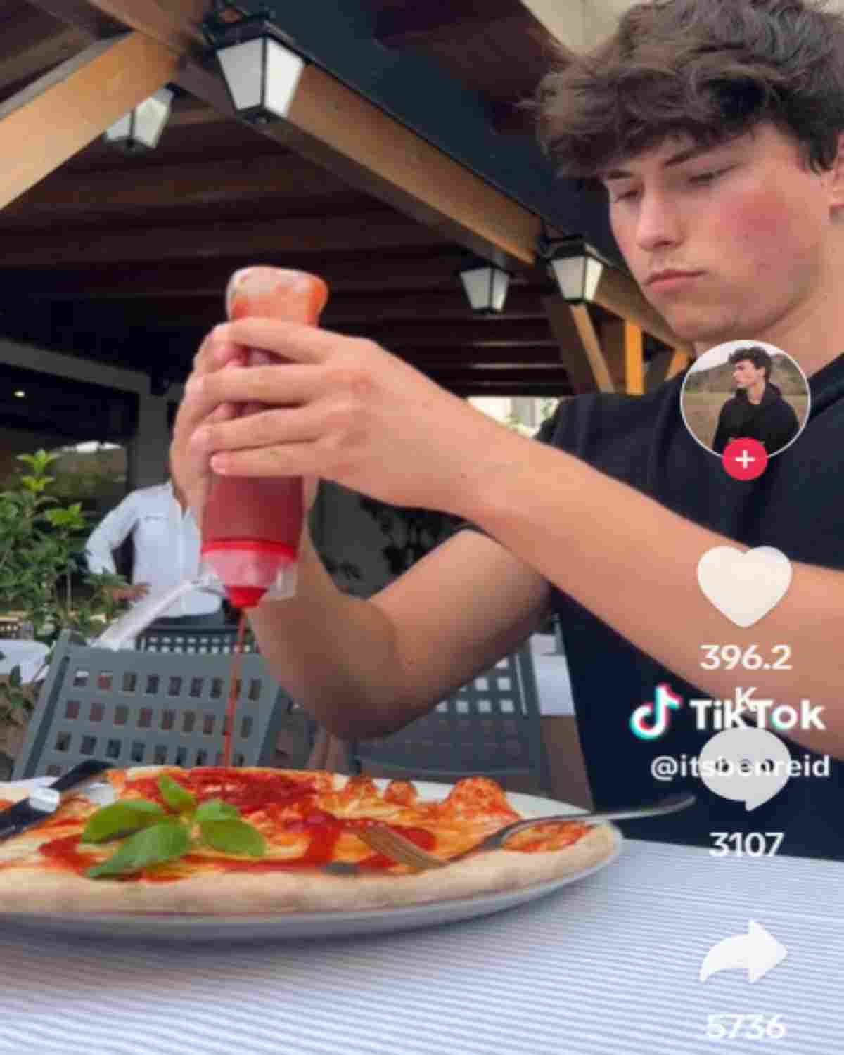 Turista riempie di ketchup una pizza italiana