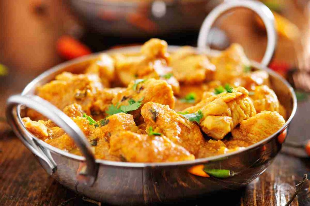 Pollo al curry in una ciotola di metallo
