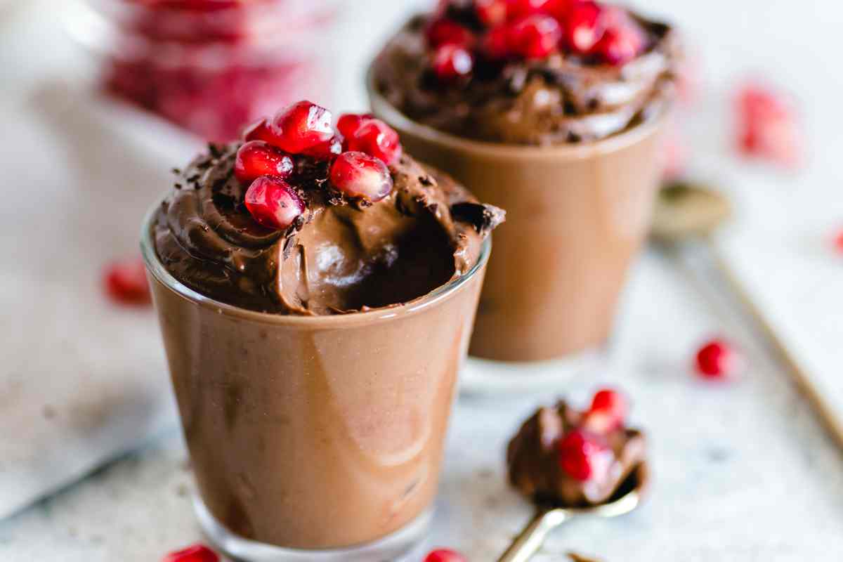 due bicchieri con la mousse al cioccolato e chicchi di melograno tra i dolci al cucchiaio veloci di questa raccolta