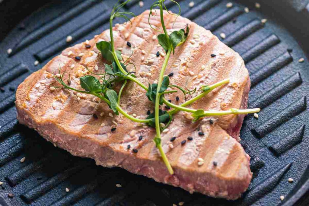 una fetta di tonno alla piastra con semi di sesamo ed erbe aromatiche