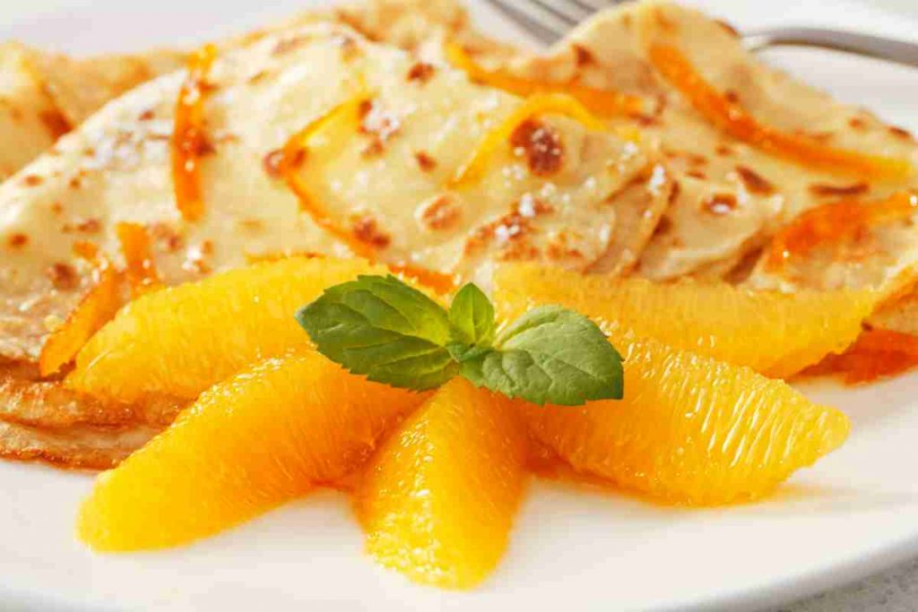 Crepes Suzette e fette di arancia 