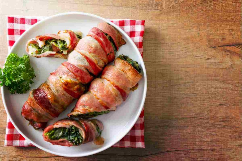 Involtini di spinaci e pancetta coppata sul piatto