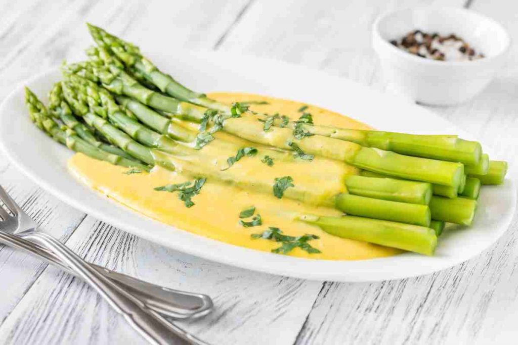 Asparagi lessi con salsa olandese e erba cipollina in piatto ovale