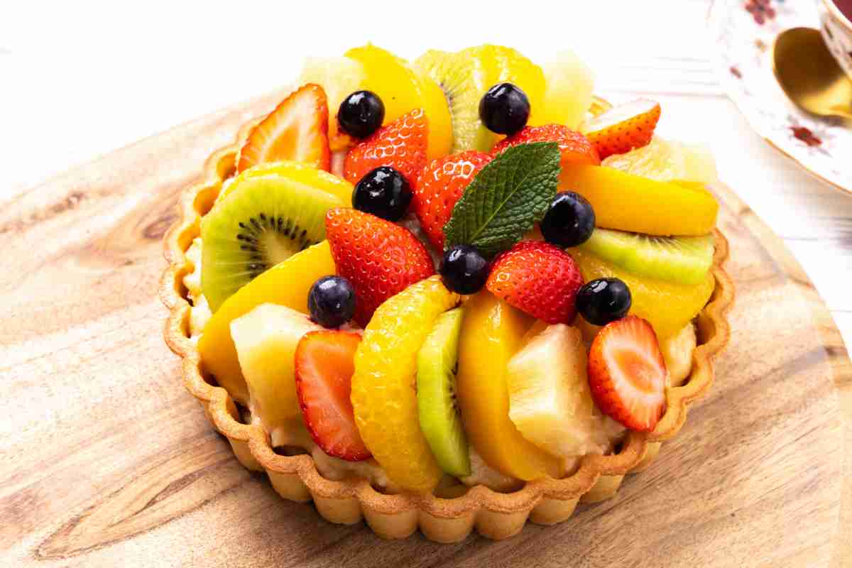 Crostata di frutta fresca con crema e fettine di frutta poste a raggiera