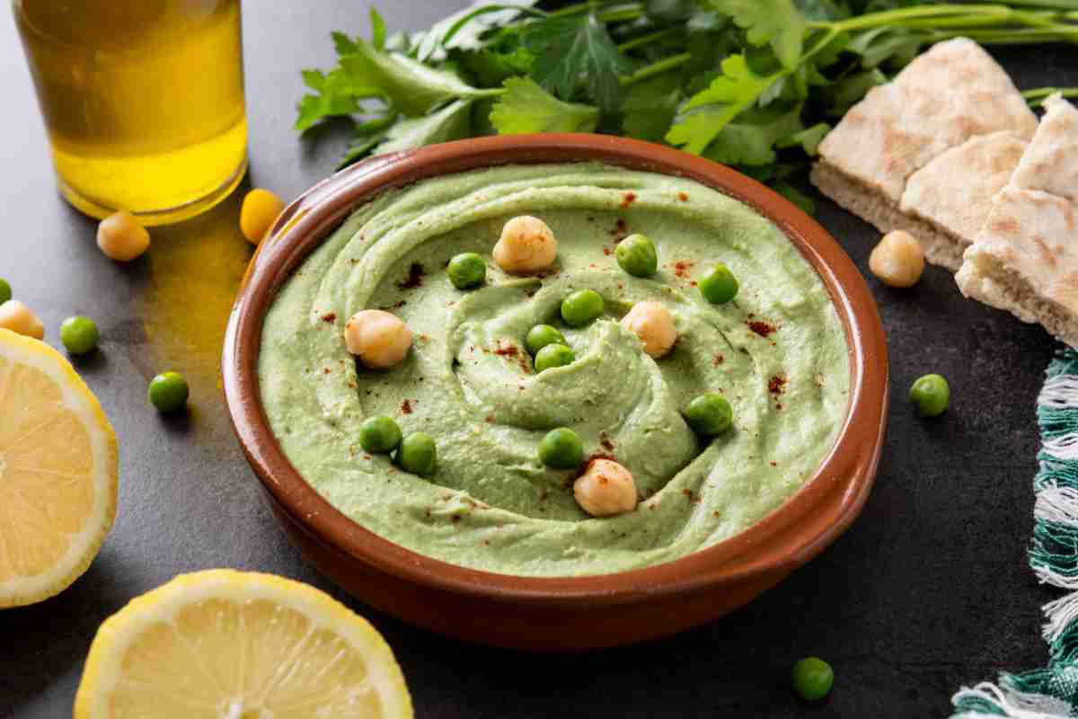 Hummus di piselli con ceci in una ciotola di coccio