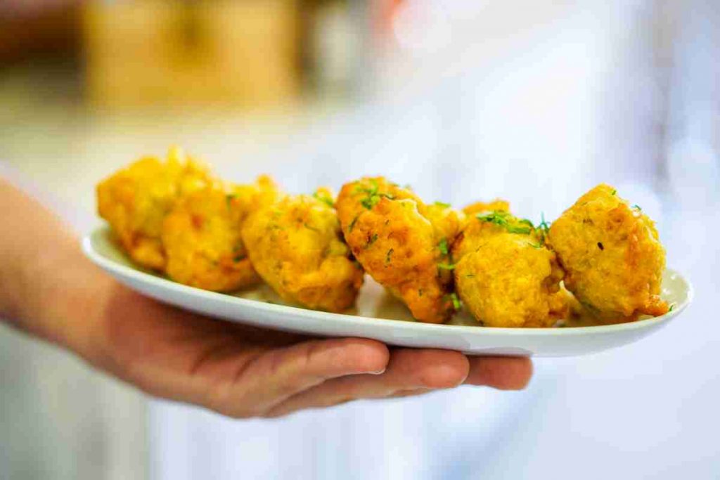 Merluzzo fritto in pastella su piatto in una mano