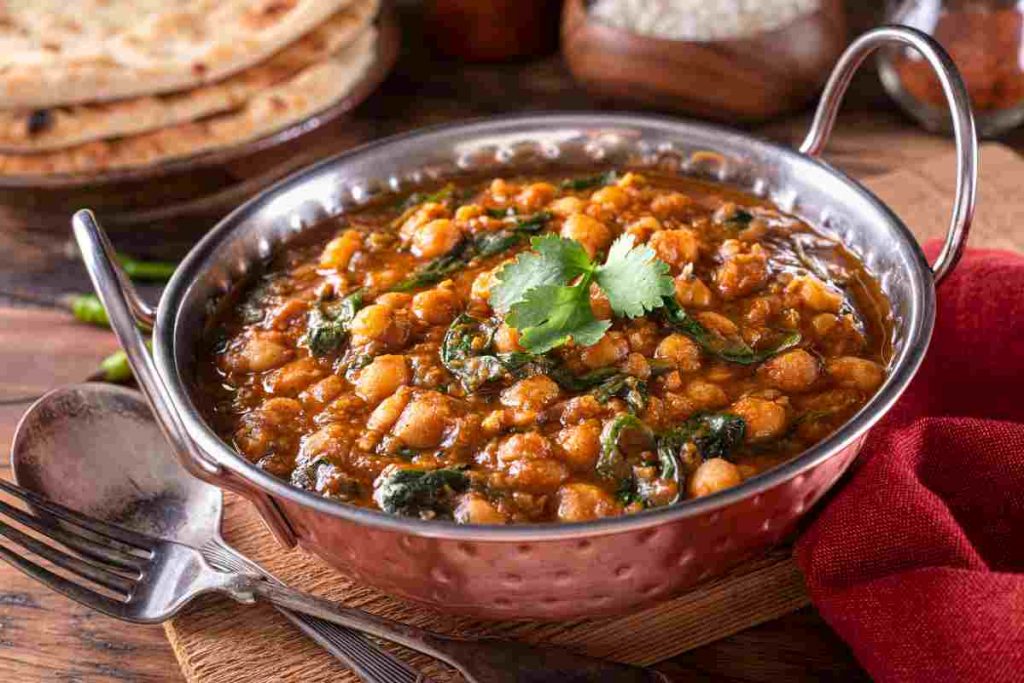 Minestra di ceci al curry e spinaci in tegame con foglioline di prezzemolo