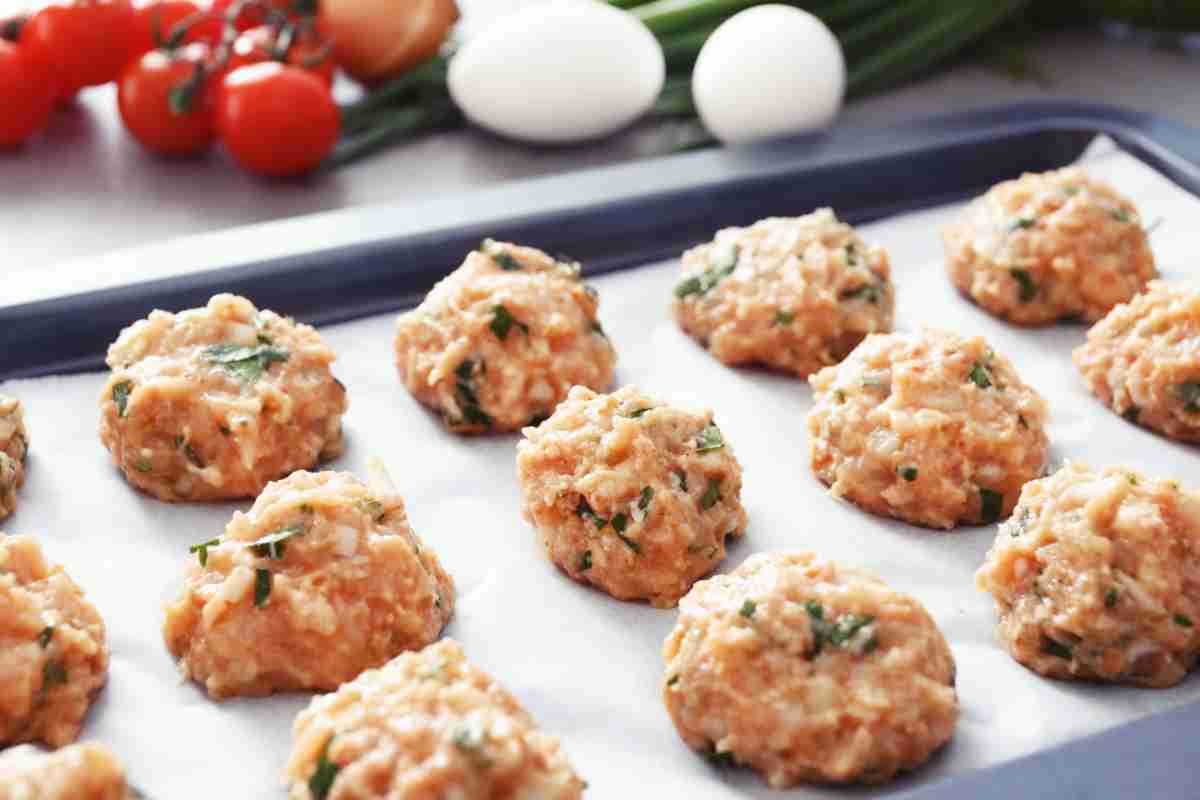 teglia con carta forno e sopra polpette di tacchino