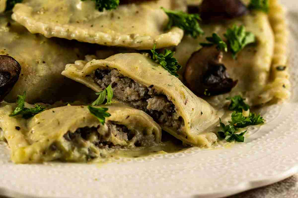 Ravioli ai funghi tagliati e visti da vicino con il ripieno