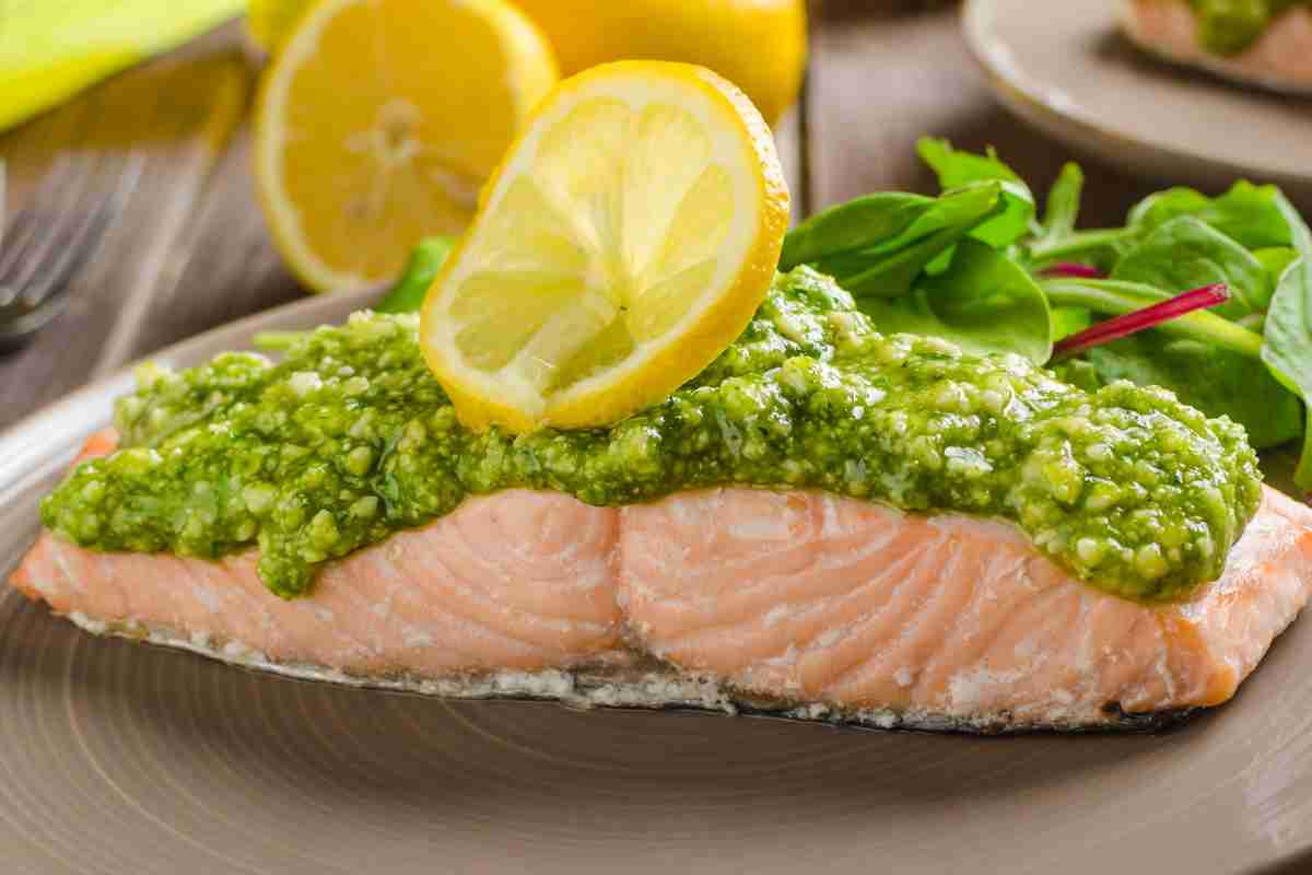 piatto con salmone al vapore con sopra pesto e insalata di contorno