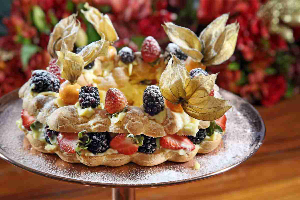 Torta bignè con namelaka e frutti di bosco su vassoio