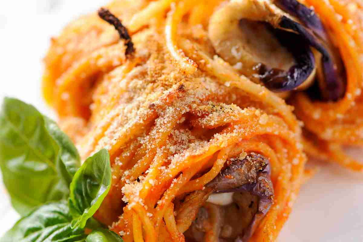 Involtini di spaghetti e melanzane in un piatto bianco