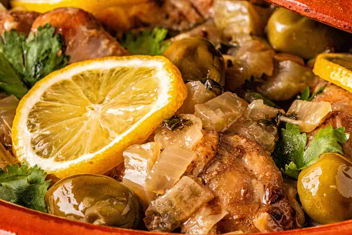 Pollo alla cacciatora in bianco in terrina di coccio guarnito con fetta di limone