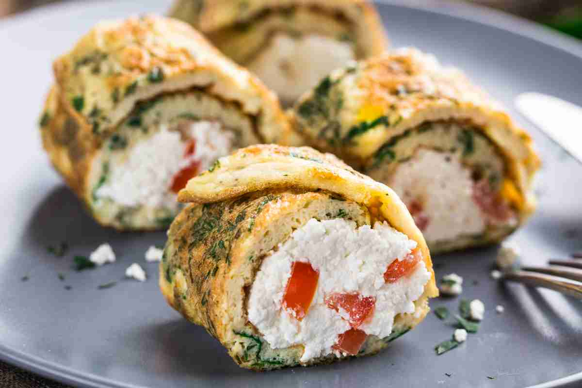 Bocconcini di rotolo di frittata con formaggio caprino e pomodori