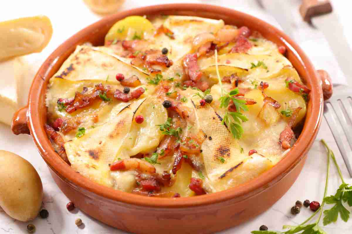 Tartiflette di patate, pancetta e formaggio in una ciotola di coccio