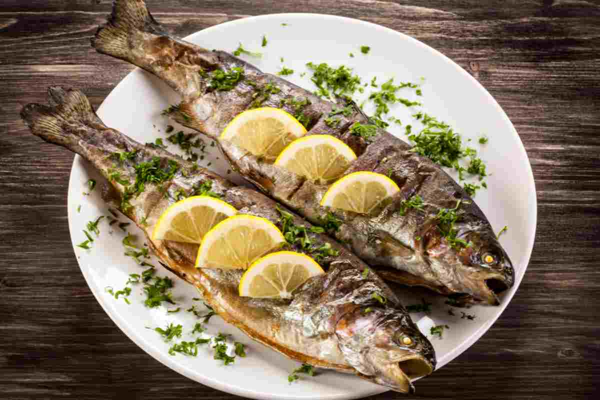 Trota grigliata con fette di limone e prezzemolo