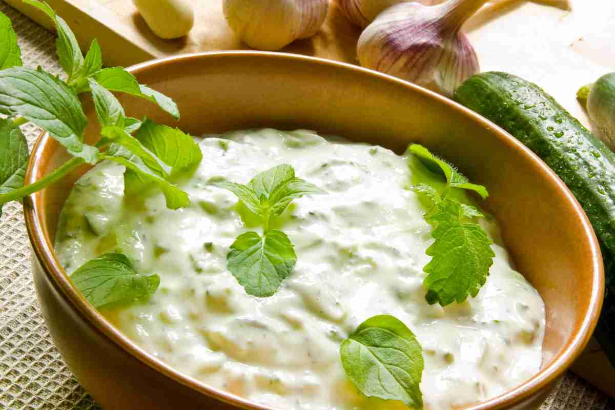 Tzatziki in una ciotola con cetriolo e aglio vicini