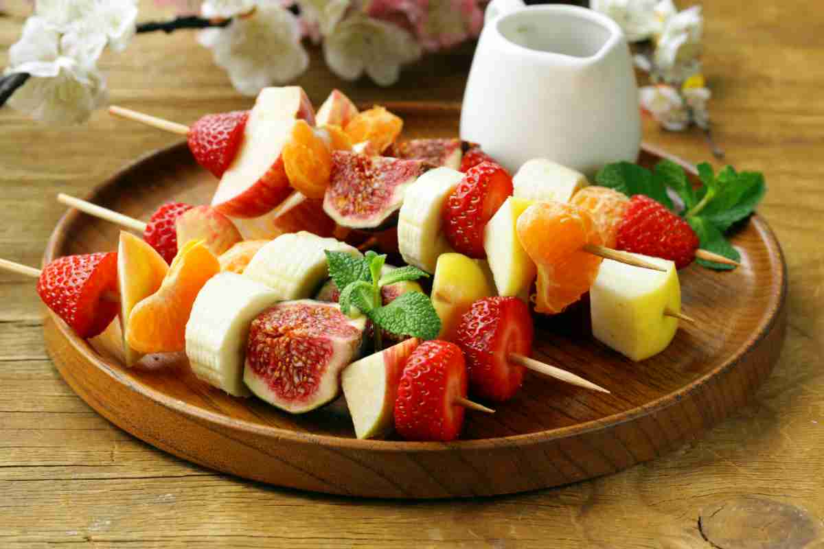 Spiedini di frutta su tavolo di legno