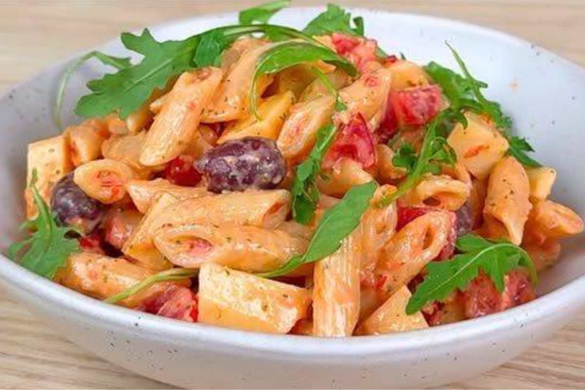 piatto con Pasta fredda con pesto di pomodorini ricotta noci basilico