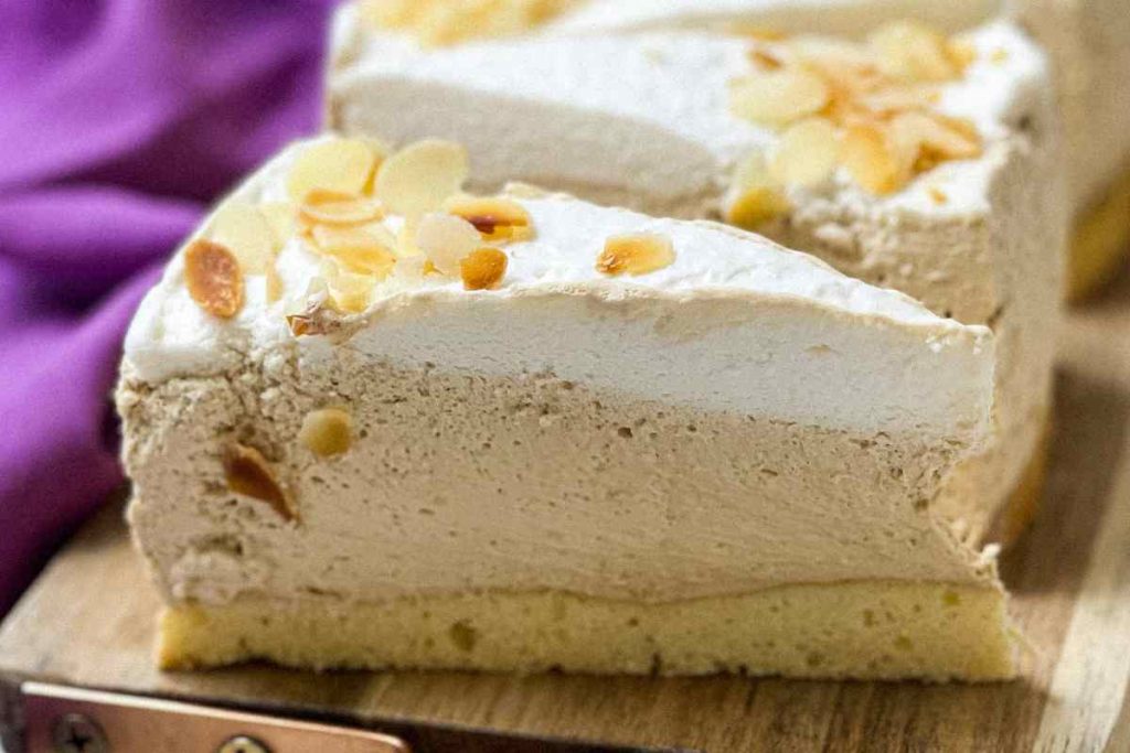 Fette di torta fredda con crema di caffè e panna su un tagliere di legno