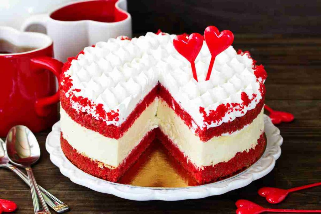 Torta red velvet con una fetta mancante e decorazioni a forma di cuore
