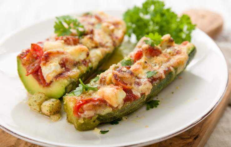 zucchine ripiene in un piatto con erbe aromatiche