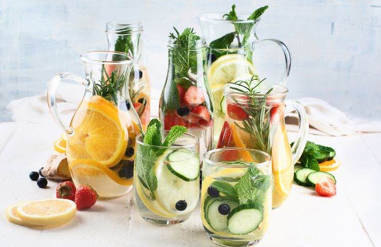 Bevande detox miste che si trovano sul tavolo e frutta fresca 