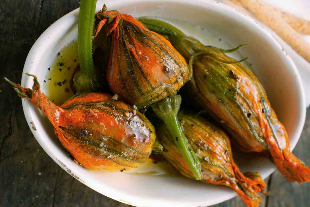 Fiori di zucca ripieni di riso cotti in padella e adagiati in una pirofila