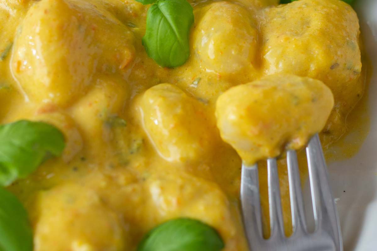 forchetta infilzata negli gnocchi allo zafferano nel piatto
