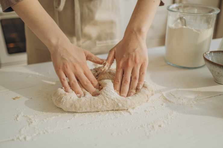 mani lavorano l'impasto della torta angelica salata