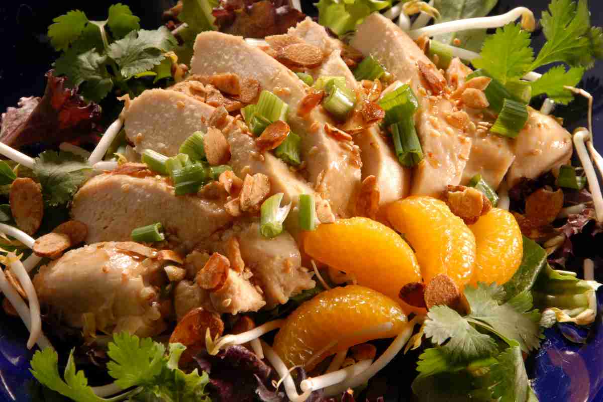 Insalata di pollo con salsa all'arancia in un piatto