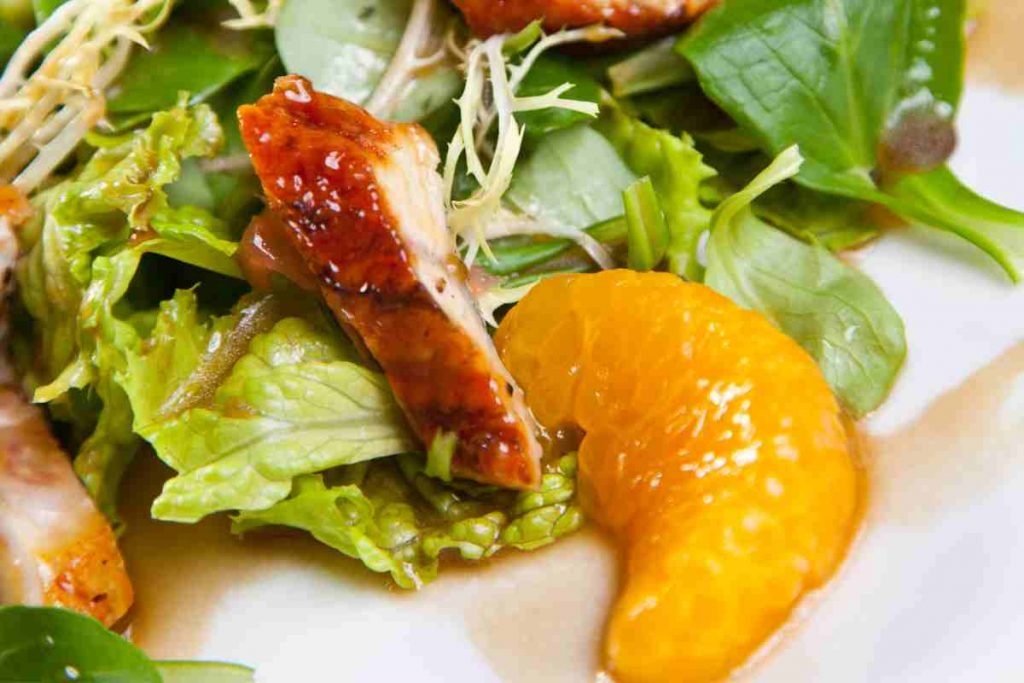 Insalata di pollo e salsa all'arancia in un piatto