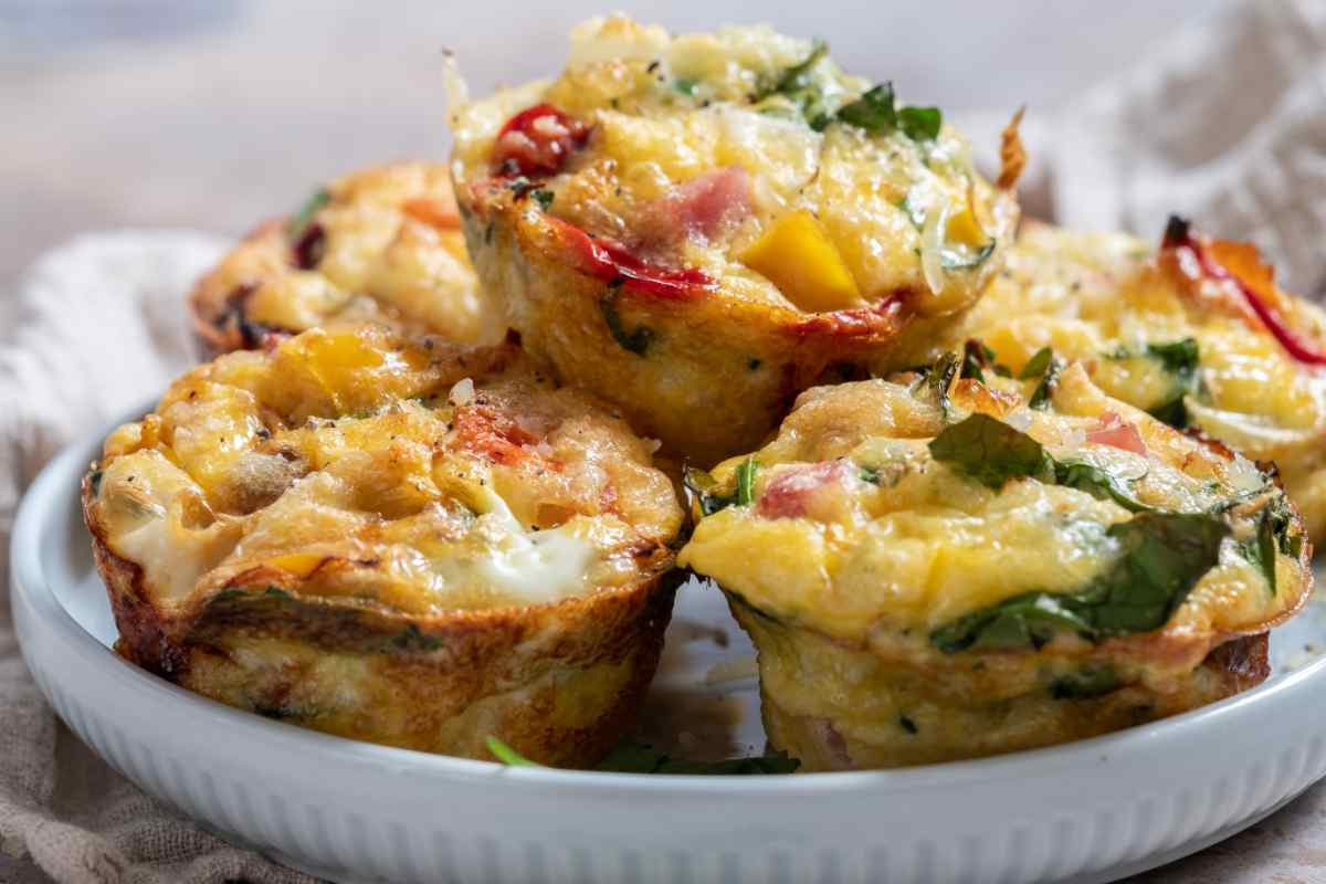 Muffin salati con prosciutto e verdure in un piatto bianco