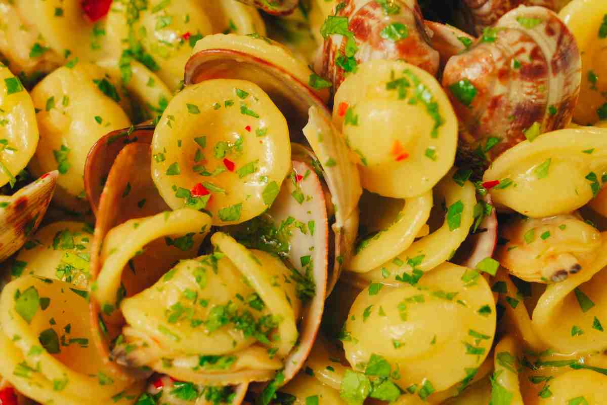 Orecchiette alle vongole con prezzemolo e peperoncino in un piatto viste da molto vicino